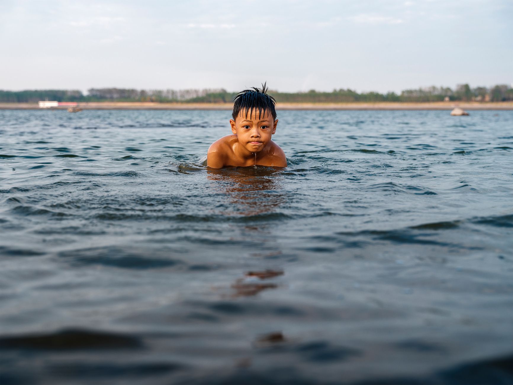 child swimming lake outdoors